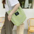 Black grid-pattern canvas shoulder bag with a magnetic buckle closure