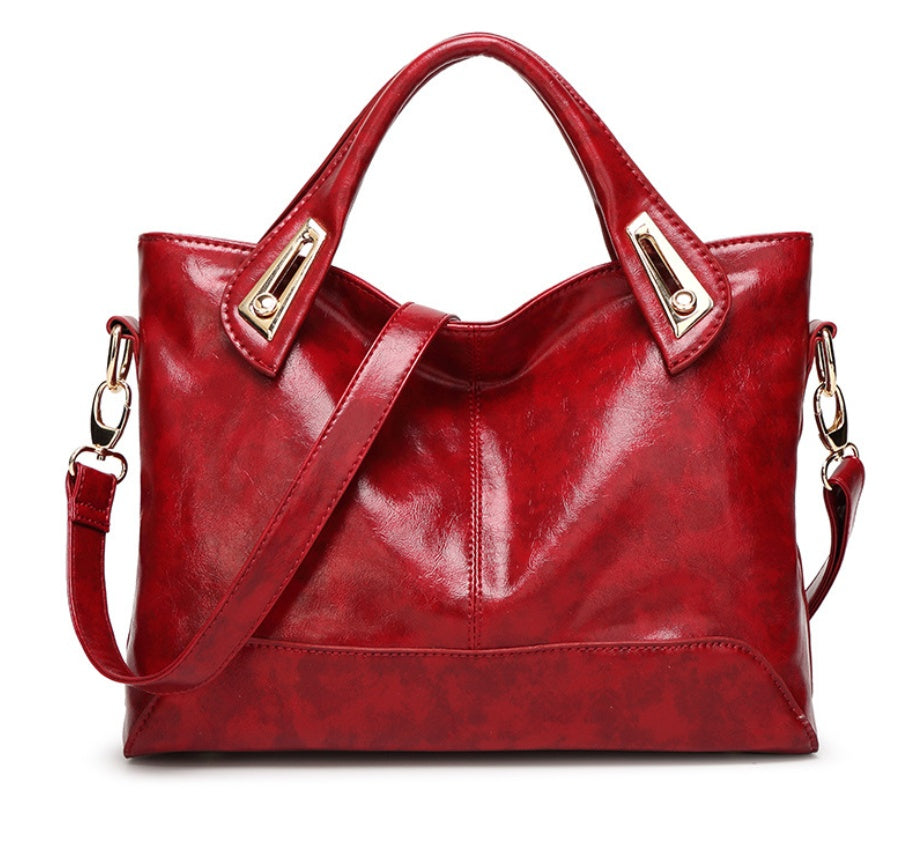 Square women's handbag featuring decorative metal accents